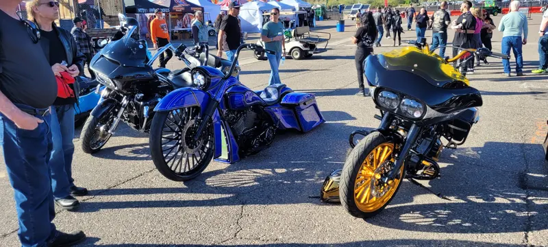 Custom baggers with gold and black wheels drawing a crowd at Arizona Bike Week 2024